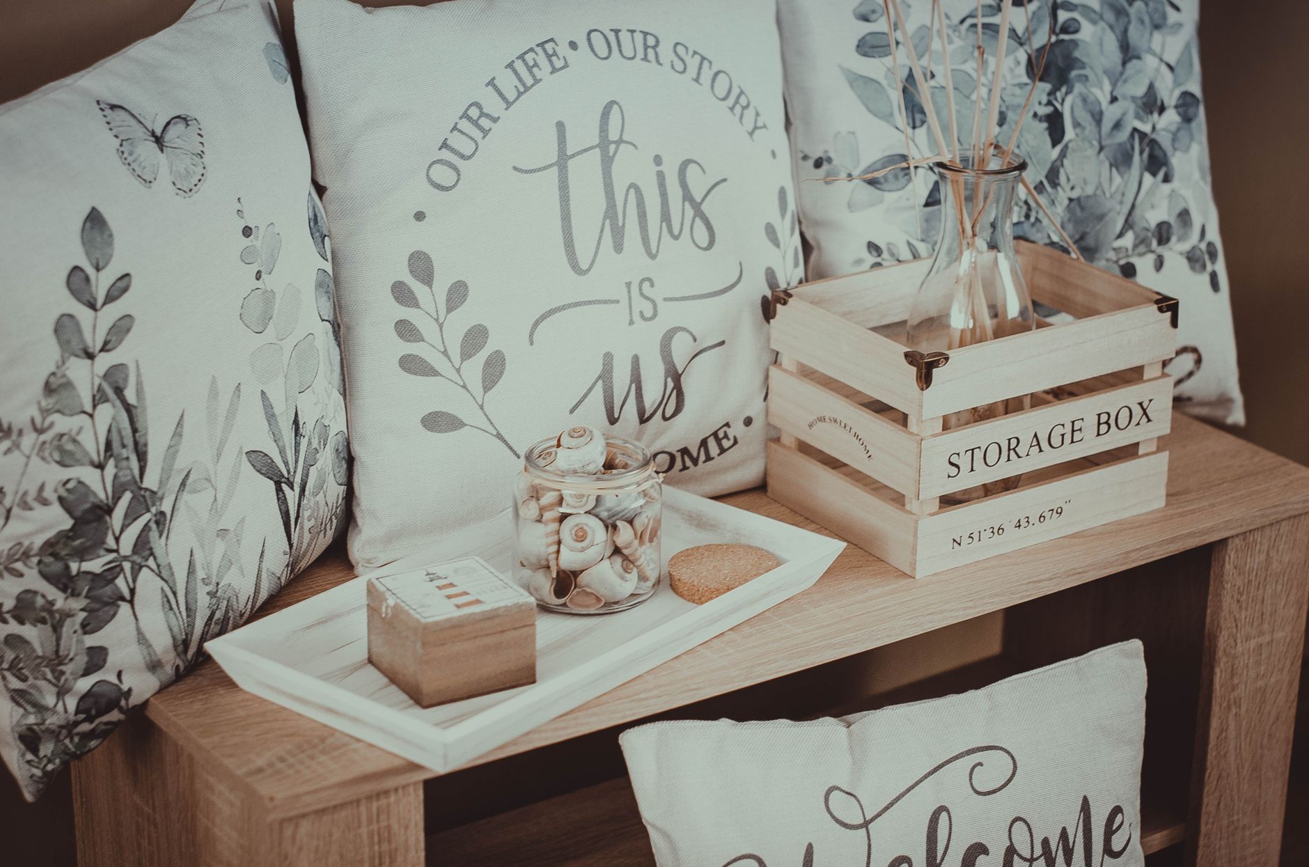 a wooden shelf with pillows and a sign that says this is our home
